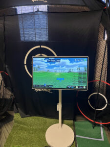 ネットの前に置いた27インチタブレットにPhiGolfの練習場画面が表示されている