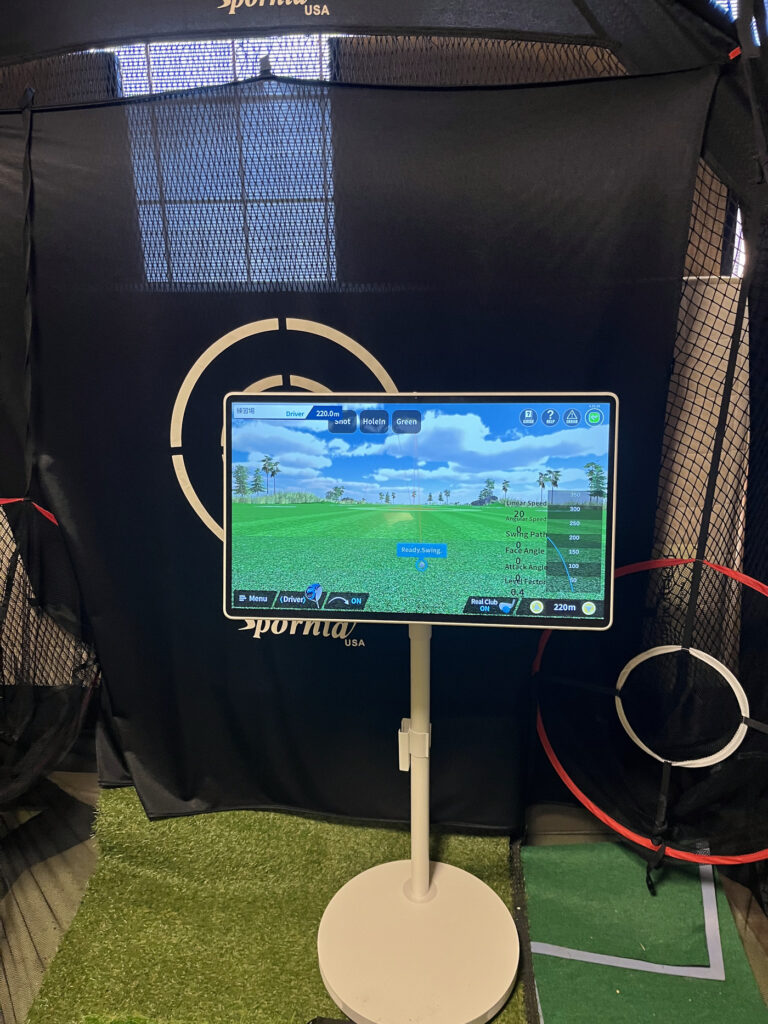 ネットの前に置いた27インチタブレットにPhiGolfの練習場画面が表示されている