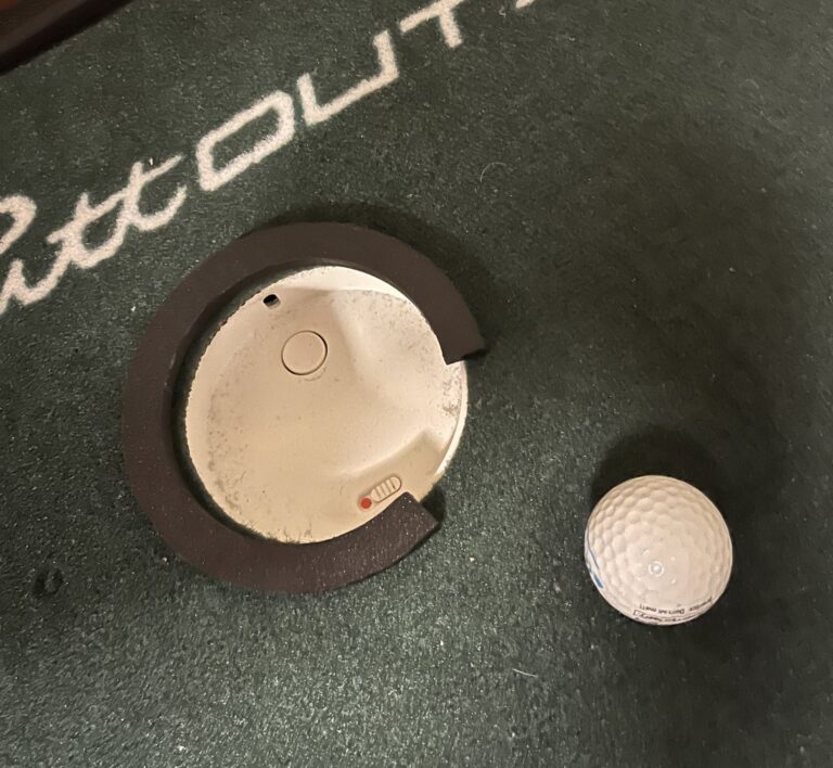 Air Breakのカップの縁に載せた黒いC字型の3Dプリンター製リング。一方向だけが開いていて、右側にゴルフボールが置かれている